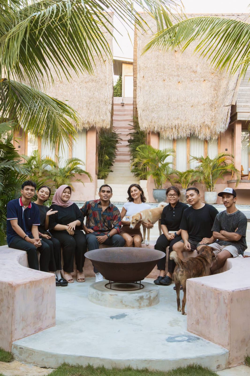 The Lulu's team sitting together around the fire bowl in the courtyard, with the dogs.